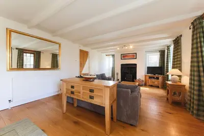 a living room with a table and a couch at November Cottage St Kew, North Cornwall Cosy Cottage in Bodmin