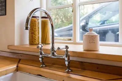 a kitchen sink with a faucet next to a window at November Cottage St Kew, North Cornwall Cosy Cottage in Bodmin