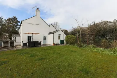 a white house with a lawn in front of it at November Cottage St Kew, North Cornwall Cosy Cottage in Bodmin