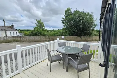 a patio with a table and chairs on a balcony at 2 bed 2 ensuite Holiday Home in St Austell