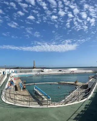 a swimming pool with people in the water at Penny's Place in Carbis Bay