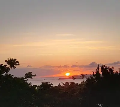 a sunset over the ocean with the sun in the sky at Penny's Place in Carbis Bay