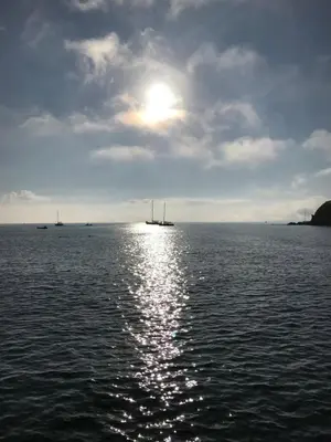 a large body of water with the sun in the sky at Seagulls Boutique Lodgings in Mevagissey