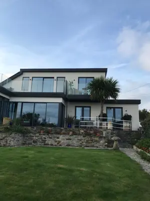 a large house with glass windows and a lawn at Seagulls Boutique Lodgings in Mevagissey