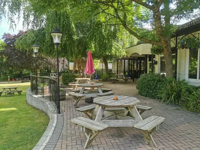 a group of picnic tables and a pink umbrella at Hayle holiday cottage in Hayle