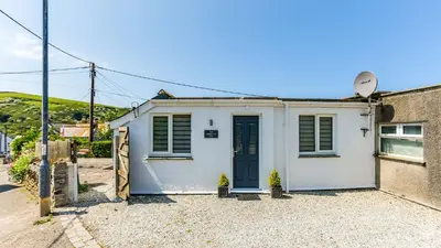 a small white house with a blue door at The Lobster Pot in Port Isaac