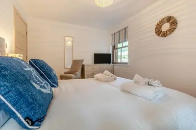 a bedroom with a large white bed with towels on it at 2 Bed in Looe oc-n29477 in Looe