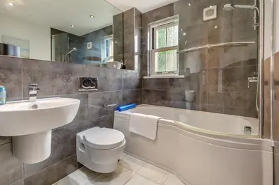 a bathroom with a sink and a tub and a toilet at 2 Bed in Looe oc-n29477 in Looe