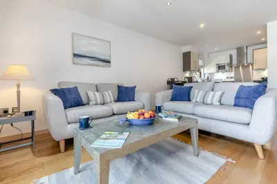 a living room with a couch and a table with a bowl of fruit at 2 Bed in Looe oc-n29477 in Looe