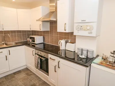 a kitchen with white cabinets and a counter top at Greenwood Apartment in St Ives
