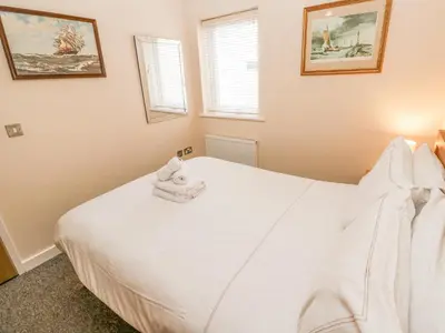 a bedroom with a white bed with towels on it at Greenwood Apartment in St Ives