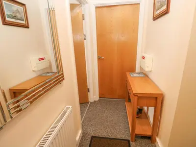 a hallway with a desk and a wooden door at Greenwood Apartment in St Ives