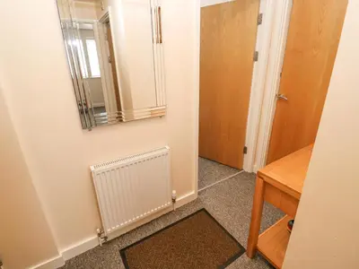 a bathroom with a mirror on the wall and a door at Greenwood Apartment in St Ives