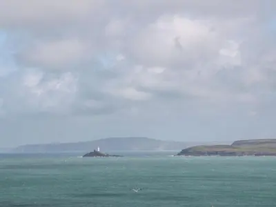 a lighthouse on an island in the middle of the ocean at Greenwood Apartment in St Ives