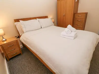 a bedroom with a large white bed with towels on it at Greenwood Apartment in St Ives
