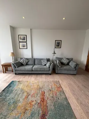 a living room with two couches and a rug at Porthminster View Luxury Sea Views Balcony, Parking, Pool, Spa & Gym in St Ives