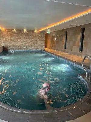 a man swimming in a swimming pool at Porthminster View Luxury Sea Views Balcony, Parking, Pool, Spa & Gym in St Ives