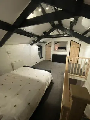a bedroom with a large bed in a attic at Bumblebee Cottage in Redruth