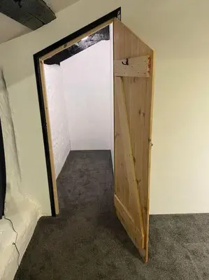 a room with a wooden door in a room at Bumblebee Cottage in Redruth