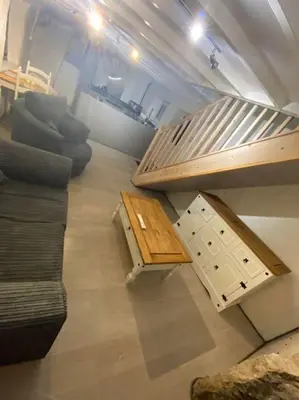 a living room with a couch and a table at Bumblebee Cottage in Redruth