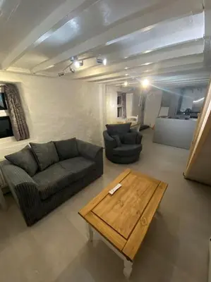a living room with two couches and a coffee table at Bumblebee Cottage in Redruth