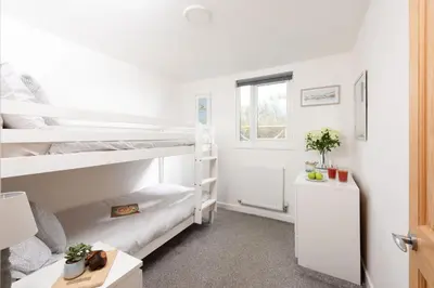 a bedroom with two bunk beds and a window at Wheal Prosper - Hot Tub - Free Wi-Fi - Parking - On-site Activities in Helston