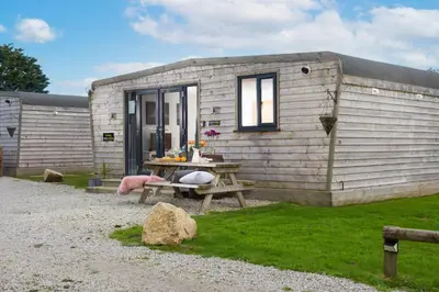 a tiny house with a picnic table in front of it at Wheal Prosper - Hot Tub - Free Wi-Fi - Parking - On-site Activities in Helston
