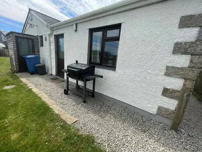 a barbecue grill sitting outside of a house at Wheal Francis - Hot Tub - Accessible Bungalow - Free Wi-Fi - Parking in Helston
