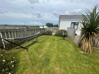 a bench in a yard next to a fence at Wheal Francis - Hot Tub - Accessible Bungalow - Free Wi-Fi - Parking in Helston