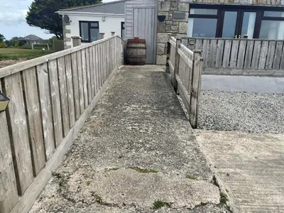 a wooden fence in front of a house at Wheal Francis - Hot Tub - Accessible Bungalow - Free Wi-Fi - Parking in Helston