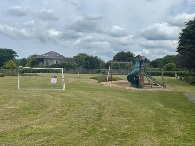 a playground with a slide and a goal at Wheal Francis - Hot Tub - Accessible Bungalow - Free Wi-Fi - Parking in Helston