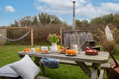 a picnic table with fruit on it in a garden at Wheal Jewel - Hot Tub - On-site Activities - Free WiFi - Parking in Helston