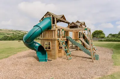 a playground with a slide and a play structure at Wheal Jewel - Hot Tub - On-site Activities - Free WiFi - Parking in Helston