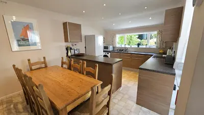 a kitchen and dining room with a wooden table at Chywartha in Porthscatho
