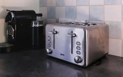 a toaster sitting on top of a counter next to a toaster at St Anthony Cottage in Saint Mawes