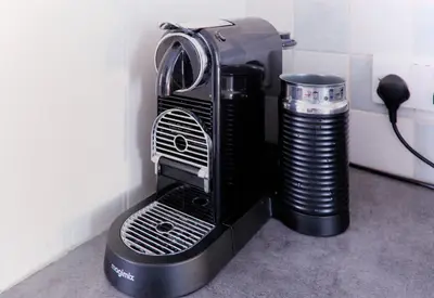 a black coffee maker and a trash can at St Anthony Cottage in Saint Mawes
