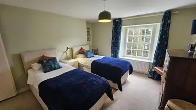 a hotel room with two beds and a window at Tregongon House in Veryan