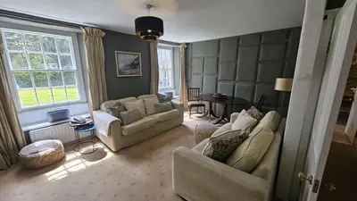 a living room with two couches and a table at Tregongon House in Veryan