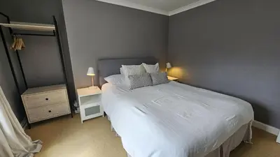 a bedroom with a white bed and a mirror at Tregongon House in Veryan