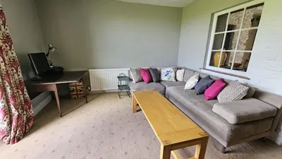 a living room with a couch and a table at Tregongon House in Veryan