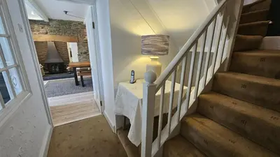 a hallway with a table with a lamp on it at Tregongon House in Veryan