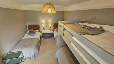 a bedroom with two twin beds and a lamp at Tregongon House in Veryan