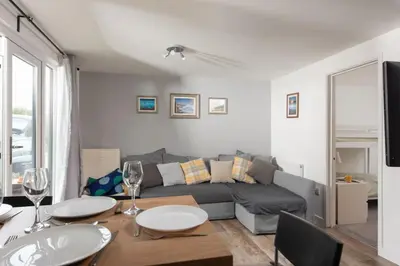 a living room with a couch and a table with wine glasses at Bushwood - Free WiFi - Parking - Pet Friendly - On-site Activities in Helston