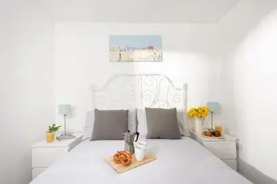 a white bedroom with a white bed with pretzels on it at Bushwood - Free WiFi - Parking - Pet Friendly - On-site Activities in Helston