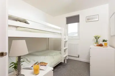 a bedroom with a bunk bed and a desk with a lamp at Bushwood - Free WiFi - Parking - Pet Friendly - On-site Activities in Helston