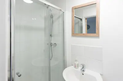 a bathroom with a shower and a sink and a mirror at Bushwood - Free WiFi - Parking - Pet Friendly - On-site Activities in Helston