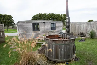 a tiny house with a tub in a yard at Wheal Rose - Hot Tub - Parking - Free WiFi - On-Site Activities in Helston