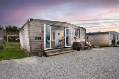 a tiny house sitting on top of a gravel yard at Wheal Rose - Hot Tub - Parking - Free WiFi - On-Site Activities in Helston