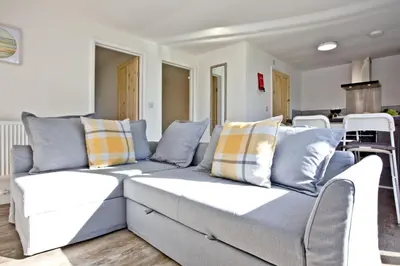 a living room with a couch with pillows at Wheal Rose - Hot Tub - Parking - Free WiFi - On-Site Activities in Helston
