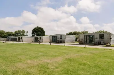 a row of three mobile homes in a field at Wheal Rose - Hot Tub - Parking - Free WiFi - On-Site Activities in Helston